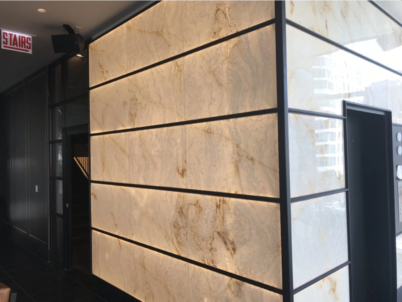 Interior photograph showing a backlit stone wall with a dark grid of joints